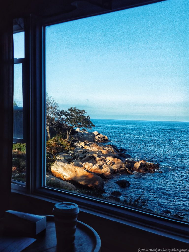 Looking out the window sipping coffee in Rockport out towards rocky shoreline.