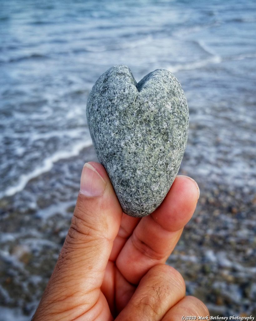 Image of a heart shaped rock at the beach.
